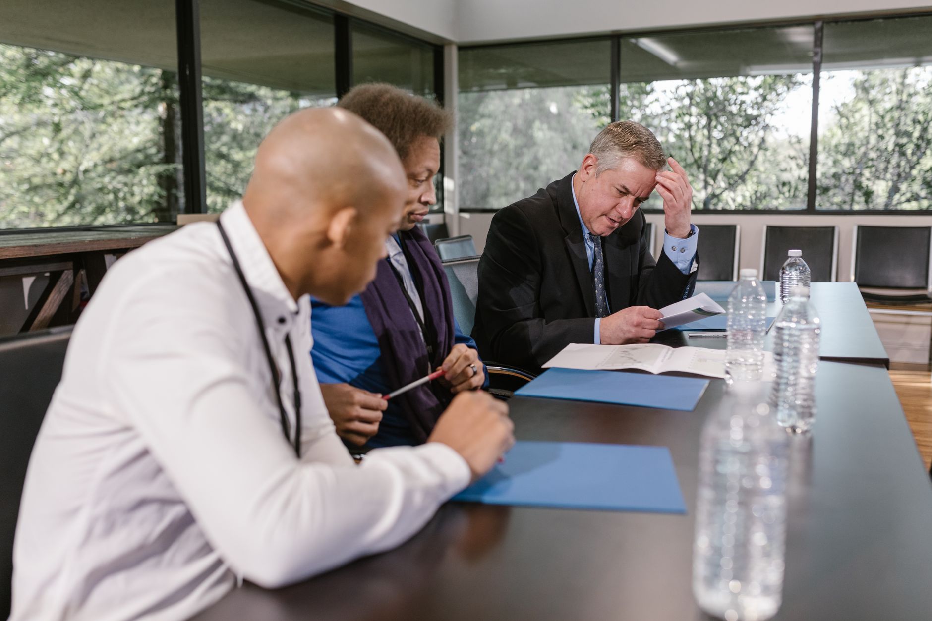 Colleagues reviewing printed documents together at a meeting table